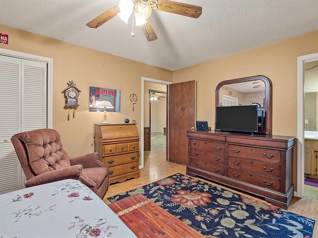 bedroom with ceiling fan, light hardwood / wood-style flooring, a closet, and a textured ceiling