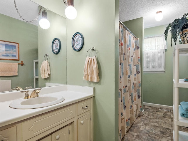 bathroom featuring a textured ceiling, vanity, and a shower with curtain