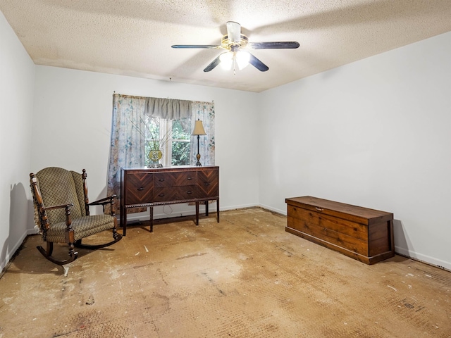 sitting room with a textured ceiling and ceiling fan