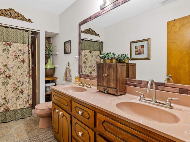 bathroom with toilet, a textured ceiling, curtained shower, and vanity