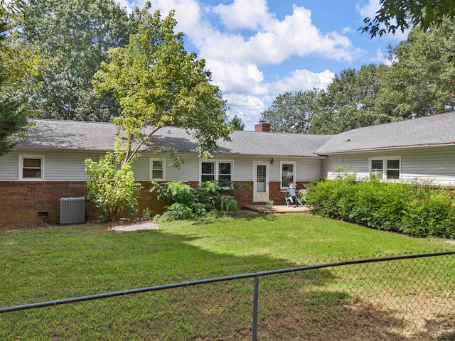 back of property with central AC and a yard