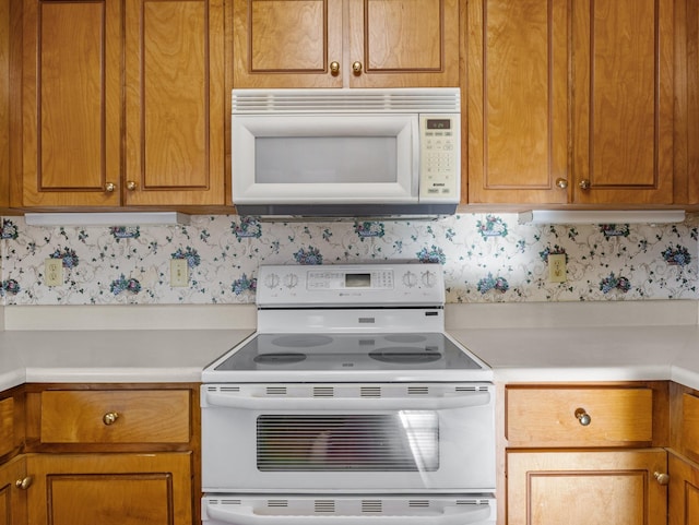 kitchen featuring white appliances and backsplash