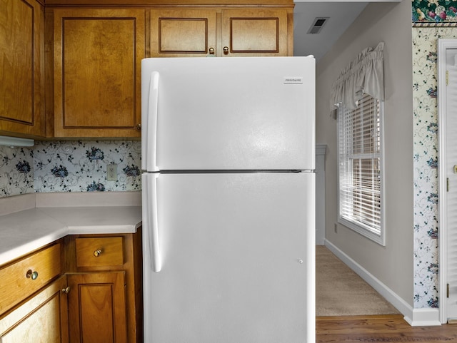 kitchen featuring wood-type flooring and white fridge