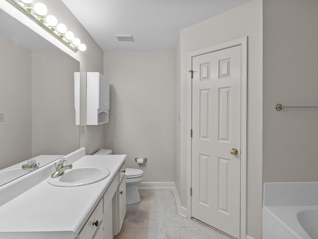 bathroom featuring a relaxing tiled tub, vanity, and toilet