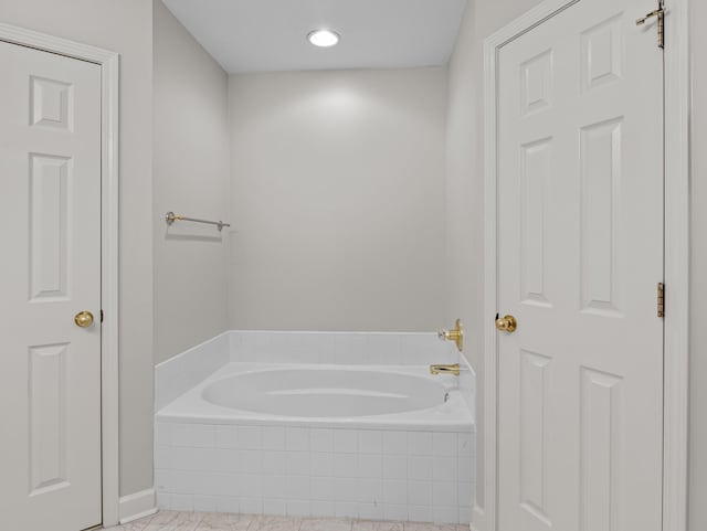 bathroom featuring tile patterned flooring and tiled tub