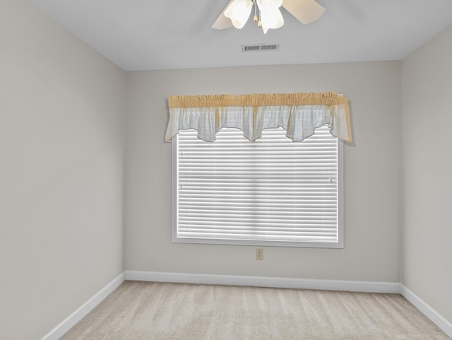 unfurnished room with ceiling fan, light carpet, and plenty of natural light