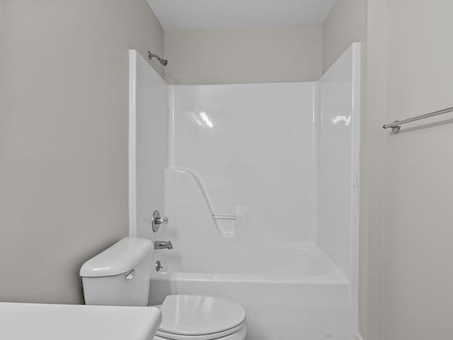 bathroom featuring bathtub / shower combination and toilet