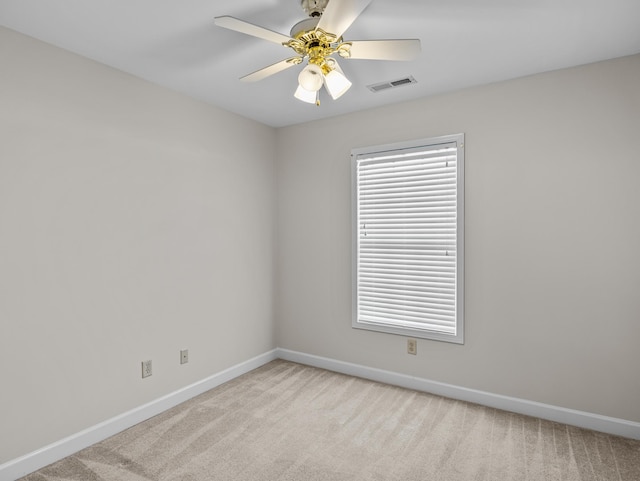 spare room featuring ceiling fan and light colored carpet