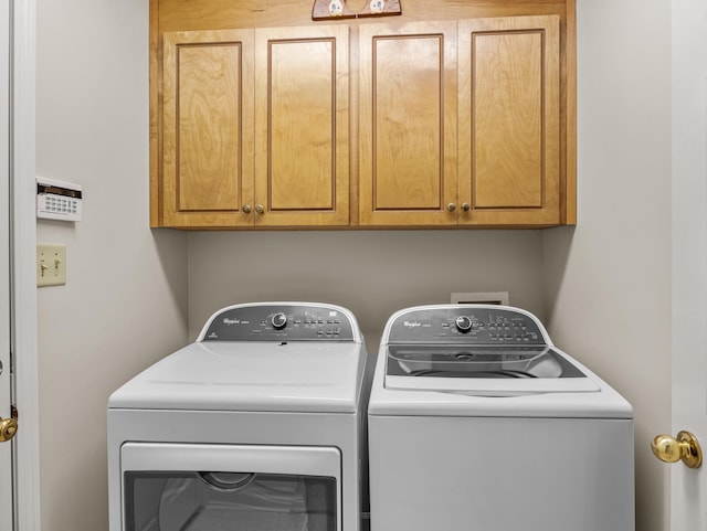 laundry area featuring washing machine and dryer and cabinets