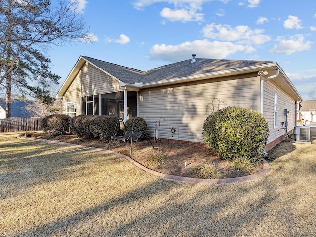 view of side of property with central air condition unit, ceiling fan, and a lawn