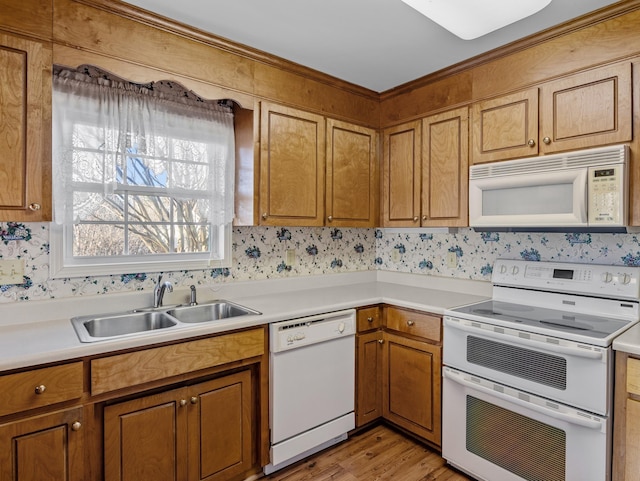 kitchen with white appliances, light hardwood / wood-style floors, and sink