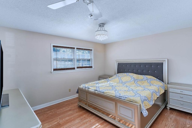 bedroom with hardwood / wood-style flooring, a textured ceiling, and ceiling fan