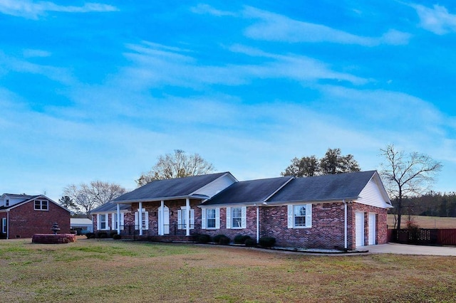 ranch-style home featuring a porch, a front lawn, and a garage