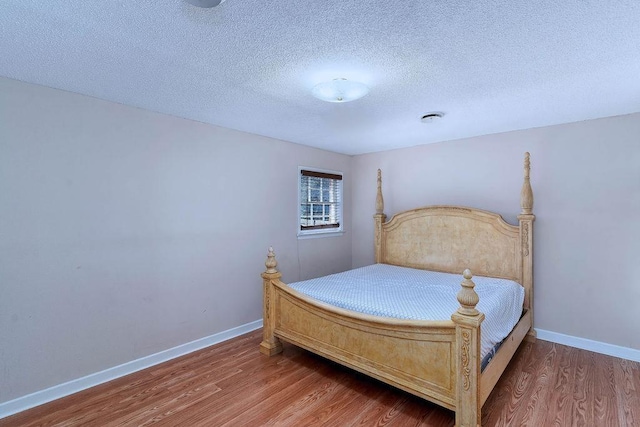 bedroom featuring a textured ceiling and wood-type flooring