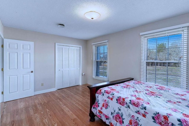 bedroom with hardwood / wood-style flooring, a textured ceiling, and a closet