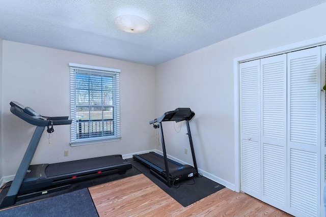 workout area featuring a textured ceiling and wood-type flooring