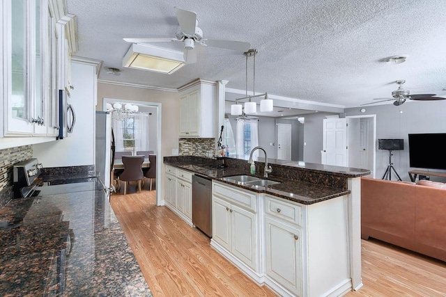 kitchen featuring appliances with stainless steel finishes, white cabinetry, hanging light fixtures, and sink