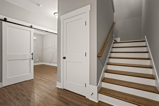 staircase featuring hardwood / wood-style flooring and a barn door