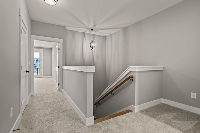 hallway featuring light colored carpet