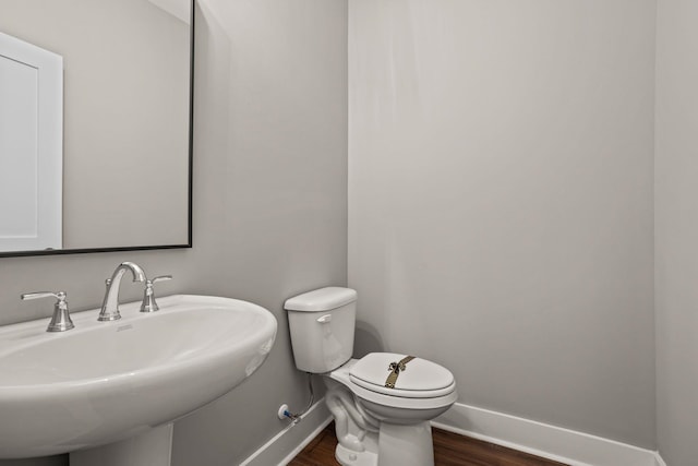 bathroom featuring sink, wood-type flooring, and toilet