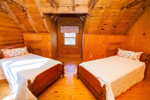 bedroom with log walls, wooden walls, light hardwood / wood-style floors, wood ceiling, and vaulted ceiling with beams