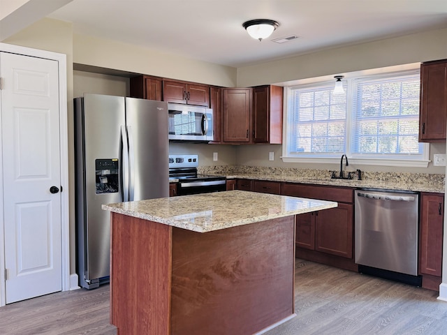 kitchen featuring sink, a kitchen island, light hardwood / wood-style floors, and appliances with stainless steel finishes