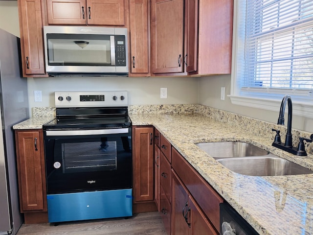 kitchen featuring sink, stainless steel appliances, light stone countertops, and dark wood-type flooring