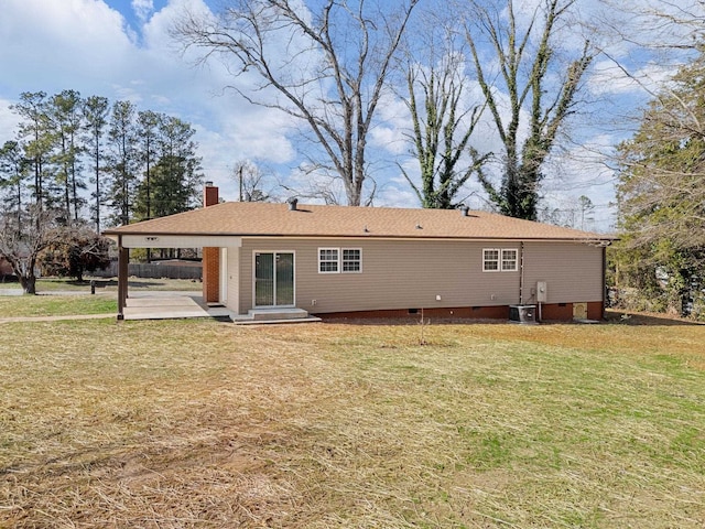 rear view of house with central AC, a patio area, and a lawn
