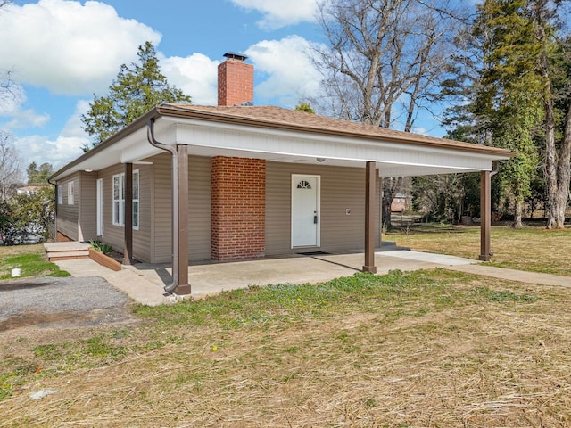 view of front of house featuring a carport and a front yard