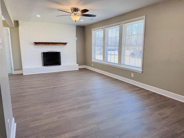 unfurnished living room featuring hardwood / wood-style floors, a fireplace, and ceiling fan