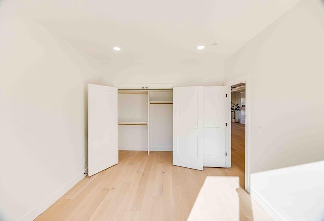 unfurnished bedroom featuring a closet and light hardwood / wood-style floors