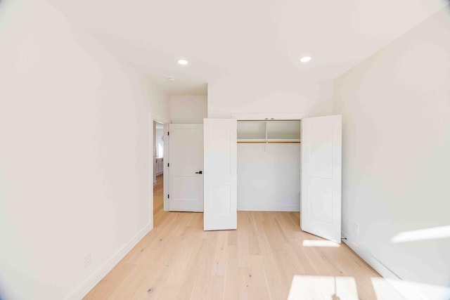 unfurnished bedroom with a closet and light hardwood / wood-style flooring