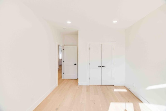 unfurnished bedroom with light hardwood / wood-style floors and a closet