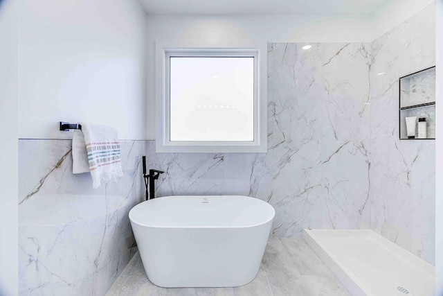 bathroom featuring tile walls and separate shower and tub