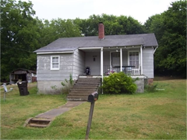 bungalow-style house with covered porch and a front lawn