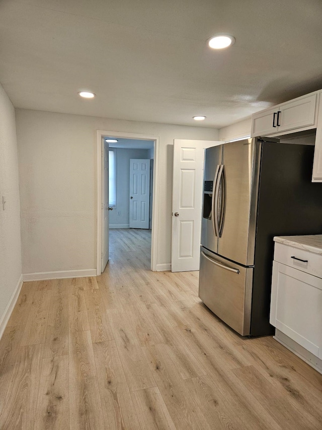 kitchen with white cabinets, light wood-type flooring, and stainless steel fridge with ice dispenser