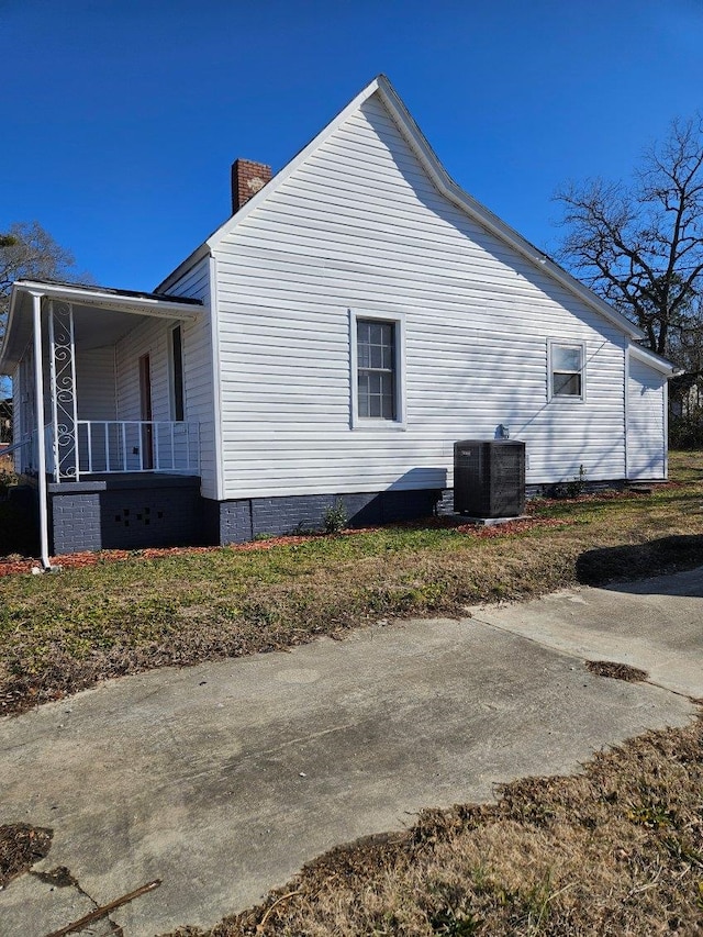 view of home's exterior with covered porch and central air condition unit