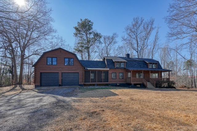 log home with a garage, a front lawn, and a porch