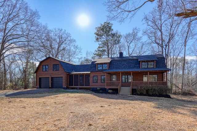 log-style house with a garage, a front yard, and a porch