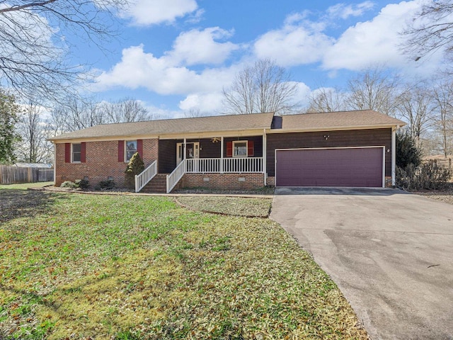 ranch-style house featuring covered porch, a front yard, and a garage