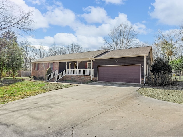 single story home featuring covered porch, a front lawn, and a garage