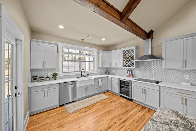 kitchen with dishwasher, beverage cooler, hanging light fixtures, wall chimney range hood, and sink