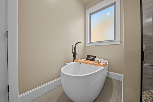 bathroom with a tub and tile patterned floors