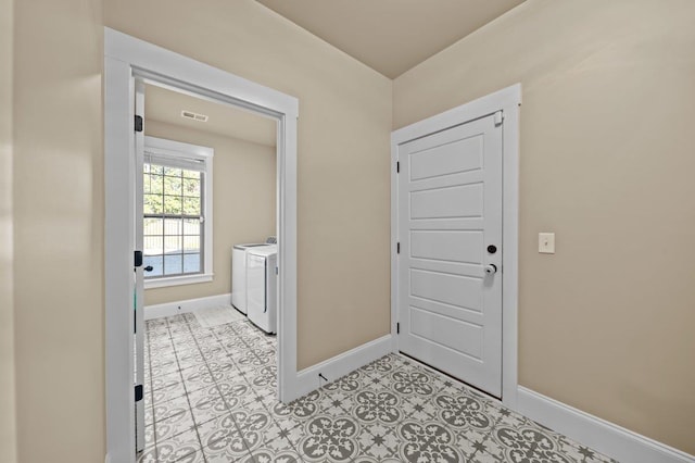 interior space with washing machine and dryer and light tile patterned floors