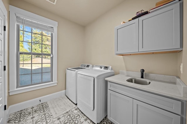 washroom featuring cabinets, light tile patterned floors, washer and clothes dryer, and sink