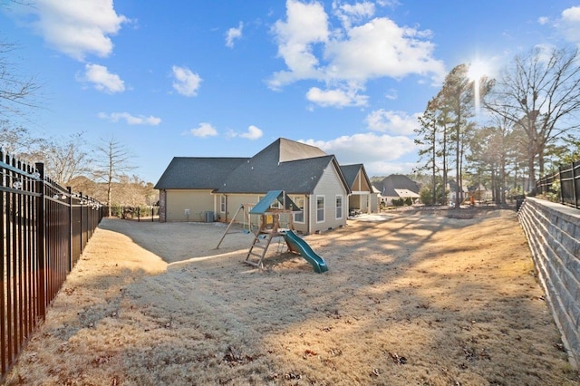 back of house with a playground