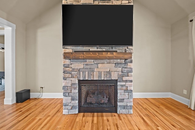 interior details featuring hardwood / wood-style floors and a stone fireplace