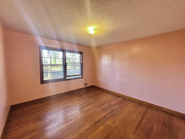 empty room with a textured ceiling and hardwood / wood-style floors