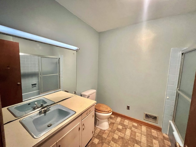 full bathroom featuring toilet, bath / shower combo with glass door, and vanity