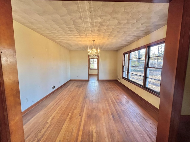 unfurnished dining area featuring light hardwood / wood-style floors and a notable chandelier